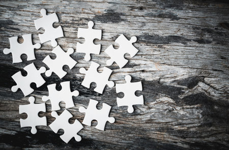White details of jigsaw puzzle piece on wooden background. Concept of working together as a business team. The idea of getting involved, working for success.の写真素材