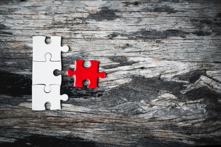 White details of jigsaw puzzle piece on wooden background. Concept of working together as a business team. The idea of getting involved, working for success.の写真素材