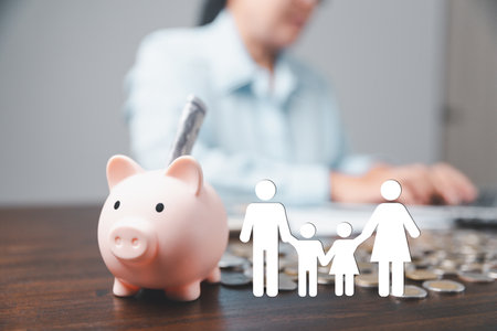 Businesswoman take a position to protect on the piggybank and paper family in hand, donation, saving, charity, family finance plan concept, fundraising, superannuation, financial crisis conceptの写真素材