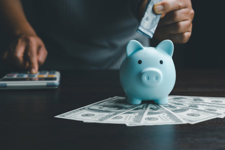 Business woman hand put dollar bill in piggy bank on wood table background, saving money wealth and financial concept, finance, investment, Financial planning.Financial planning deposit for retirementの写真素材