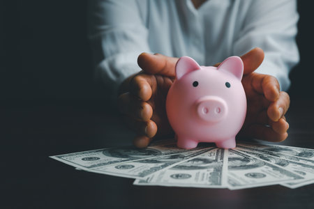 Business woman hand protect piggy bank on wood table background, saving money wealth and financial concept, finance, investment, Financial planning. Financial planning deposit for retirement.の写真素材