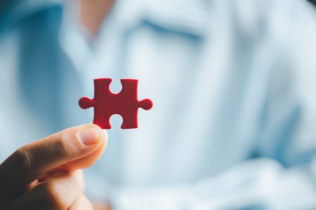 Business woman person hand holding puzzle piece idea for strategy and solution. Closeup part of one red jigsaw connect together. Concept of join cooperation success teamwork-problem corporate teamの写真素材