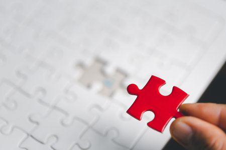 Business woman person hand holding puzzle piece idea for strategy and solution. Closeup part of one red jigsaw connect together. Concept of join cooperation success teamwork-problem corporate teamの写真素材