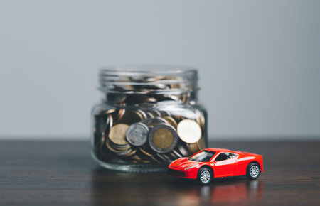 Car and house model with coins and financial document on wooden table. Asset approval concepts...