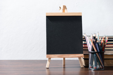 Back to school background with books on wooden table over chalkboardの写真素材