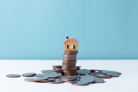 Property tax.investment planning.business real estate. View Of coin stack with house model, mortgage...