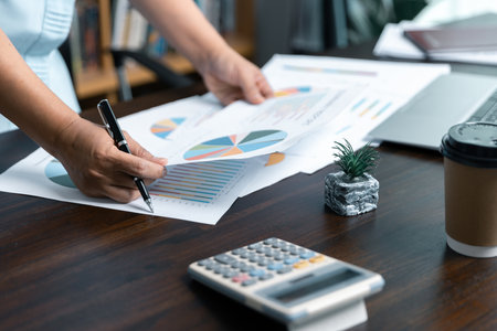 Businesswomen working to analyze, work together to discuss company financial statistics, brainstorm ideas, and graph documents on the table.の写真素材