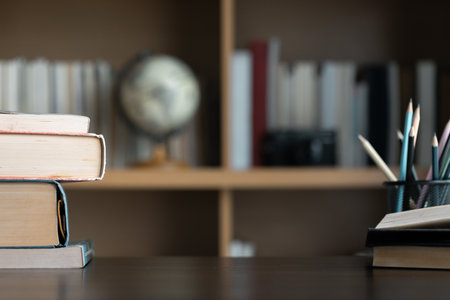 Education learning concept. Book in library with old open textbook, stack piles of literature text archive on reading desk, aisle of bookshelves in school study class room background for academicの写真素材
