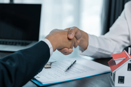 House model with agent and customer discussing for contract to buy, get insurance or loan real estate or property. Approved mortgage application form, concerning mortgage loan offer.の写真素材