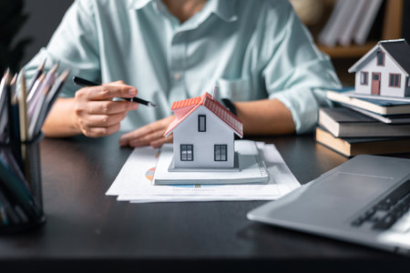 Mortgage property insurance dream moving home and real estate concept.Female calculate finance expenditures on machine, manage plan family household budget, insurance or loan real estate or property.の写真素材