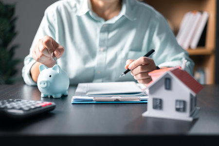 Mortgage property insurance dream moving home and real estate concept.Female calculate finance expenditures on machine, manage plan family household budget, insurance or loan real estate or property.の写真素材