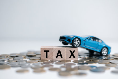 Car tax concept.close up stack of coins and tax wooden text with toy car.saving money for transport, manage for success business. Planning to manage transportation finance costs.の写真素材