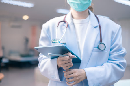 Healthcare and medical concept. Nurse handed the stethoscope to the doctor in the hospital to provide medical care to the person, ensuring their health with proper medicine and physician oversight.の写真素材
