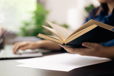 Online academy, student and woman conduct research on their laptops, people work on desktops in...