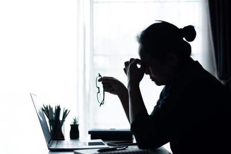 Businesswoman faced challenging problem at office, navigating work stress and using her computer to find solutions amidst feelings of depression. problem, woman, job, business, stress, depression.の写真素材
