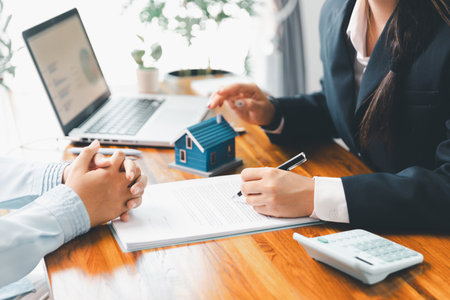 Home loan officer uses calculator with house plan loan real estate or property. important to loan calculator seek real estate, finance insurance advice ensure smart financial decisions for business.の写真素材