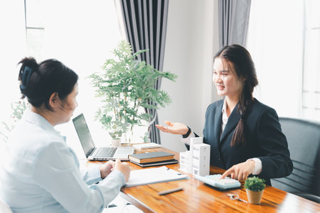 Home loan officer uses calculator with house plan loan real estate or property. important to loan calculator seek real estate, finance insurance advice ensure smart financial decisions for business.の写真素材