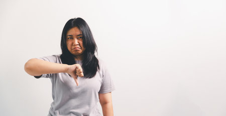 Asian girl expresses dislike, person express negative feeling, concept business complaint from customer ensuring employee satisfaction negative feedback to prevent mental strain customer dislikeの写真素材
