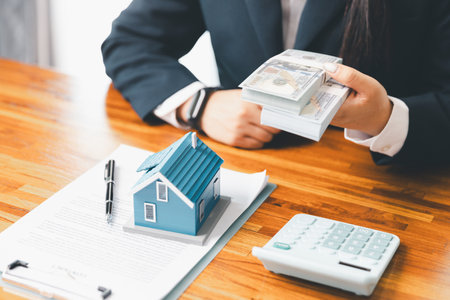 Property buyer with banknotes and buy from real estate agencies in office. Explain present information about home and mortgage purchases. real estate trading concept. Real estate trading, buy, sellの写真素材