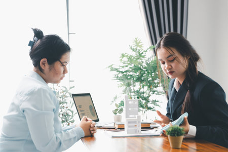 Home loan officer uses calculator with house plan loan real estate or property. important to loan calculator seek real estate, finance insurance advice ensure smart financial decisions for business.の写真素材
