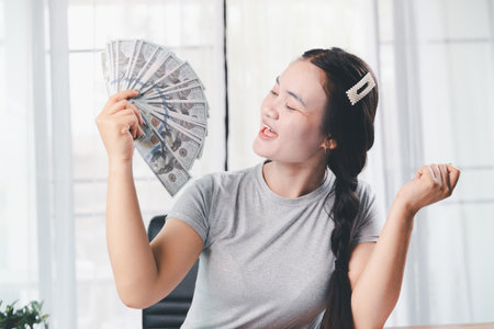 Business, finance and employment, entrepreneur and money concept. Successful young asian office manager, businesswoman showing earned cash, smiling satisfied holding dollars, money dollar billsの写真素材