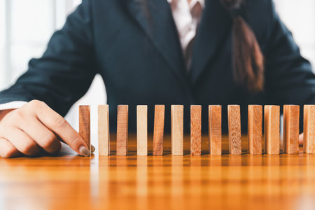 Business risk control concept, Businesswoman protect wooden block fall to planning and strategy in risk to business alternative and prevent. investment insurance business.の写真素材