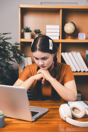 Homeschool Asian girl student learning virtual internet online class from school teacher by remote meeting. Female teaching by headphone. concept. student with computerの写真素材