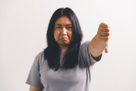 Asian girl expresses dislike, person express negative feeling, concept business complaint from customer ensuring employee satisfaction negative feedback to prevent mental strain customer dislikeの写真素材