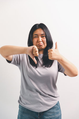 Asian girl expresses dislike, person express negative feeling, concept business complaint from customer ensuring employee satisfaction negative feedback to prevent mental strainの写真素材