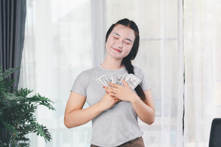 Business, finance and employment, entrepreneur and money concept. Successful young asian office manager, businesswoman showing earned cash, smiling satisfied holding dollars, money dollar billsの写真素材