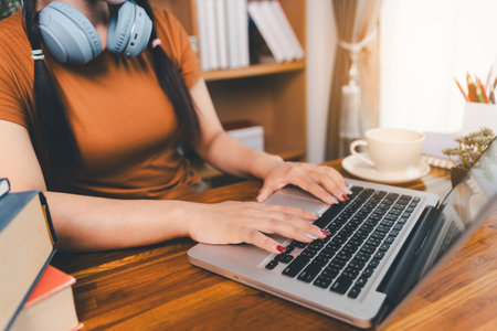 woman sitting at desk working on laptop taking notes in notebook, female studying online, watching webinar using computer, writing check list. Remote college school education, e learning concept.の写真素材
