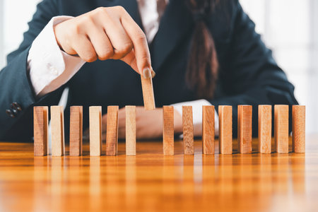 Business risk control concept, Businesswoman protect wooden block fall to planning and strategy in risk to business alternative and prevent. investment insurance business.の写真素材