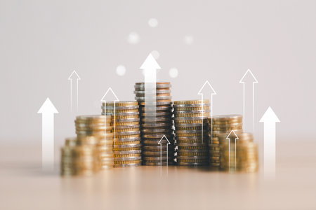 Stacks of coins with upward arrows representing financial growth, investment success, profit increase, wealth accumulation, economic development and money savings concept.の写真素材