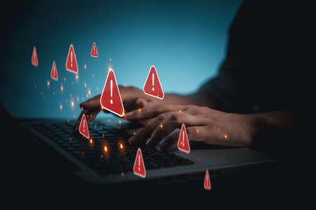 Person using phone and laptop is shown online with red warning signs indicating potential security threats. Cybersecurity technology, system warning on hacked alerts. System warning error popup.の写真素材