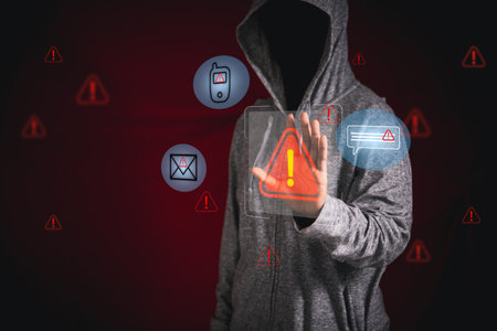 Concept of cyberattack is illustrated by hand reaching toward digital red alert icons, symbolizing...