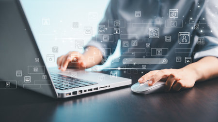 A person using a laptop and computer mouse with floating digital interface icons, representing...