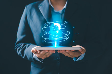 A business professional holding digital tablet with a glowing holographic padlock icon, representing cybersecurity, data protection, privacy, secure technology and modern digital security solutions.の写真素材