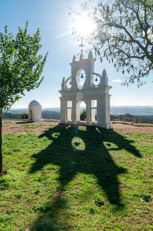 Photograph taken at sunset of a bell tower in the middle of the fieldの写真素材