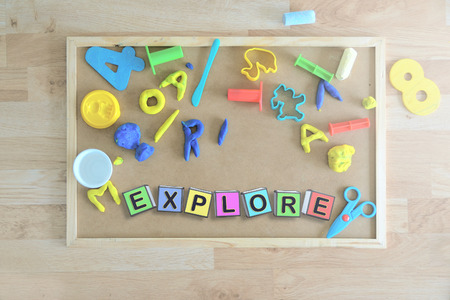 Some colored cube letters on a blackboard in a classroom forming the word EXPLORE. Children education concept.の写真素材