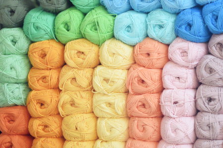 Some colorful balls of wool on a shelf of a new business shop. Colored background.