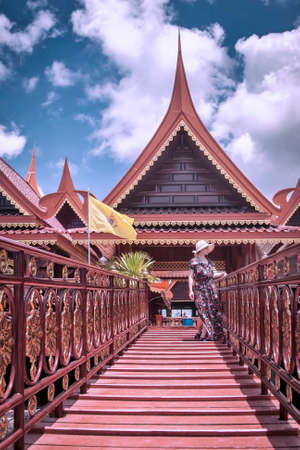 A girl stands on a bridge near buildings in Thailandの写真素材