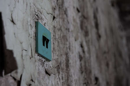A blue switch on a ragged wall. An old abandoned house, hopelessness.の写真素材