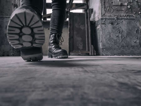 The sole of a shoe and feet on the floor in an old abandoned building. Shabby walls. Beautiful shoes.の写真素材