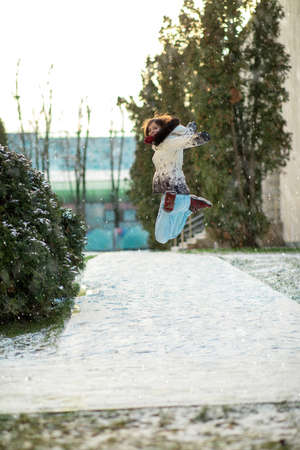 high jump of a beautiful girl in winterの写真素材