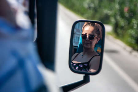 Portrait of a girl in the rearview mirror