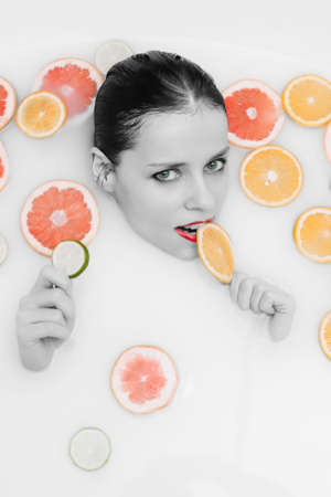 Black and white portrait of a girl in a fruit bath