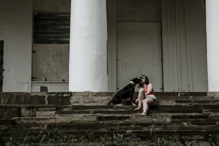 Girl and dog on the steps of an old abandoned buildingの写真素材