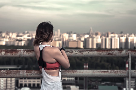 Beautiful girl on the roof of a high-rise skyscraperの写真素材
