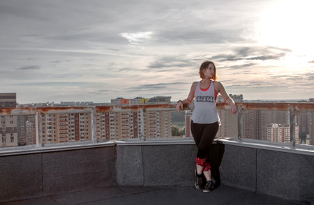 Beautiful girl on the roof of a high-rise skyscraperの写真素材