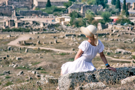 girl sitting on an ancient stoneの写真素材